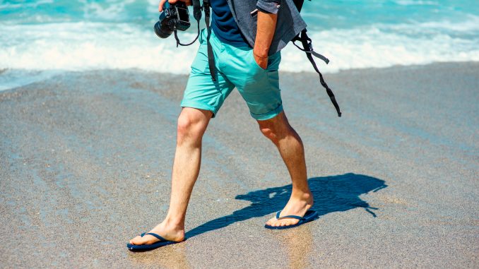 Man in shorts walking on beach