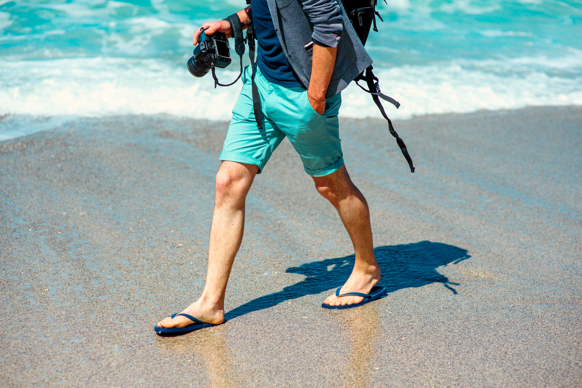 Man in shorts walking on beach