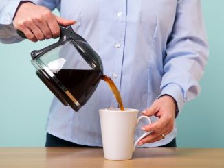 Woman pouring coffee on a mug