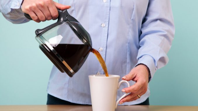 Woman pouring coffee on a mug