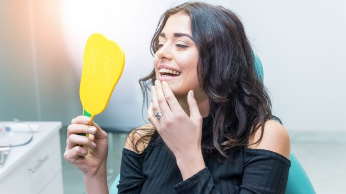 Woman checking her smile on the mirror