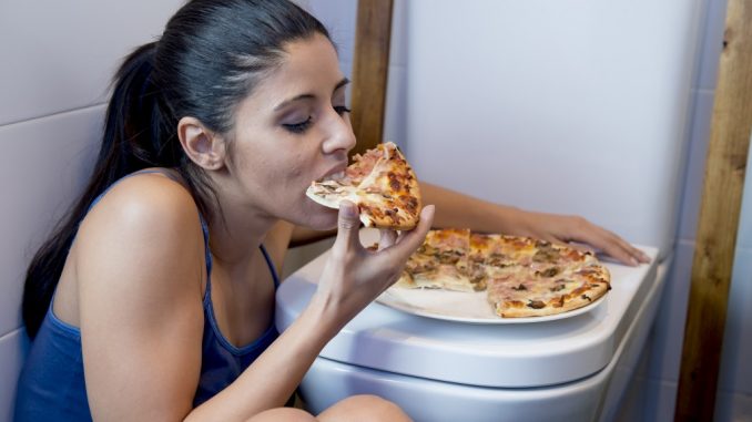 Girl eating pizza in a toilet