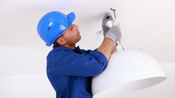 Electrician installing a ceiling light