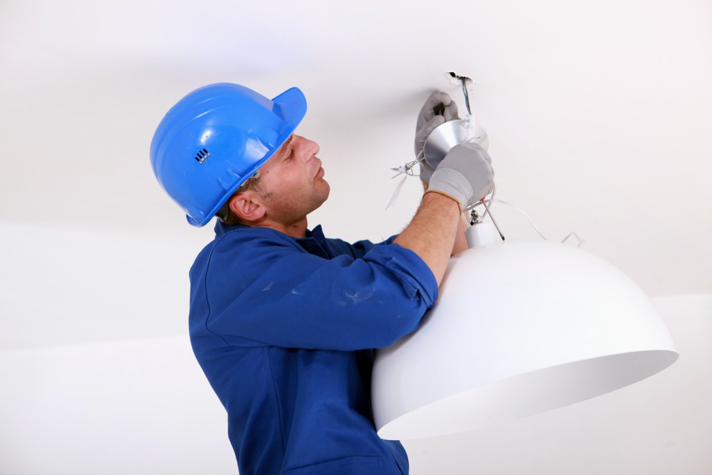 Electrician installing a ceiling light
