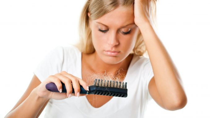 woman looking at her damaged hair