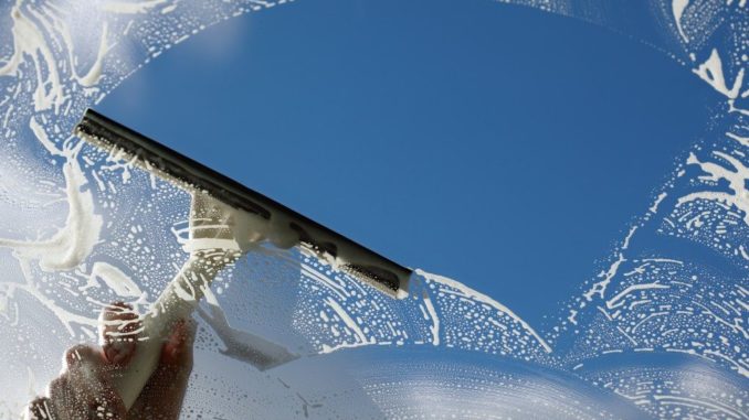 Window cleaner washing a window