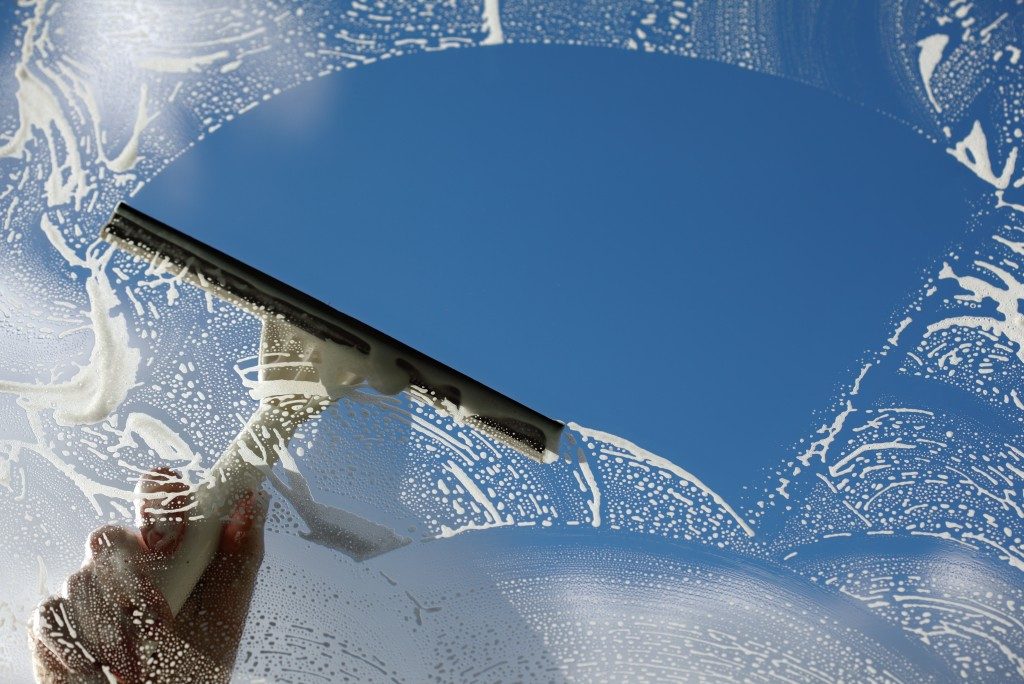 Window cleaner washing a window