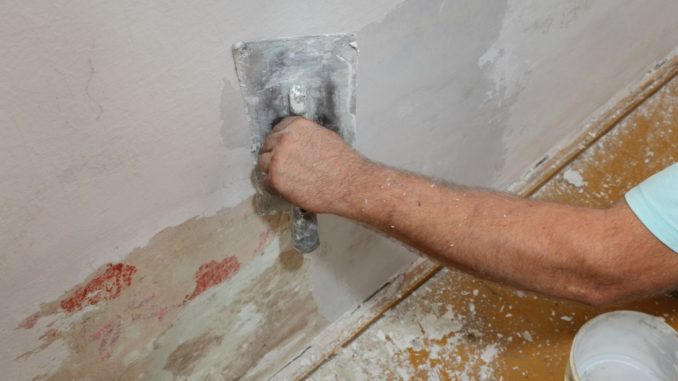 man fixing house wall
