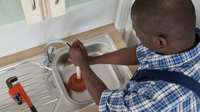 Plumber unclogging the drain