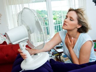 Woman using a fan at home
