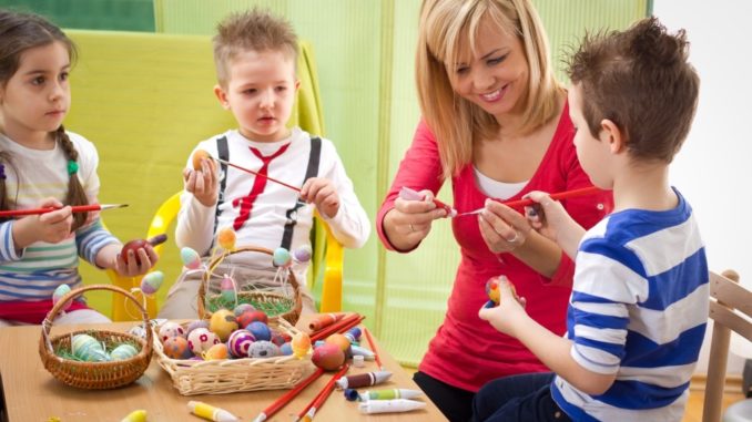 Woman painting eggs with kids