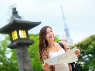 sian tourist woman with map searching for directions with the Tokyo Skytree tower in the background