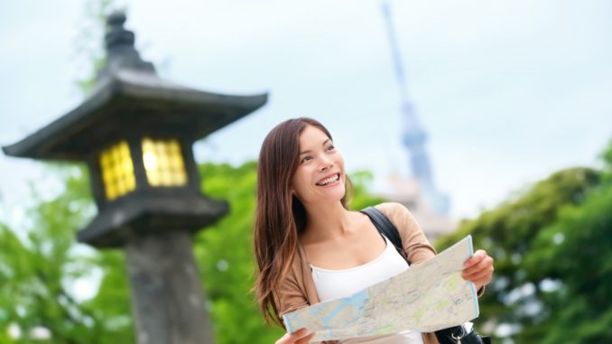 sian tourist woman with map searching for directions with the Tokyo Skytree tower in the background