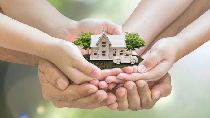 hands holding a small house model