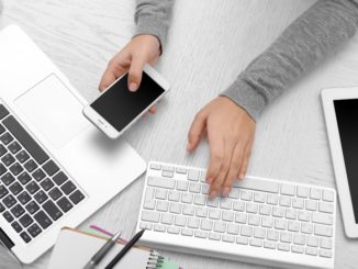 woman using smartphone and laptop