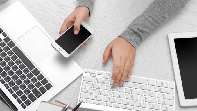 woman using smartphone and laptop