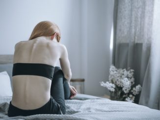 Bulimic woman sitting on a bed