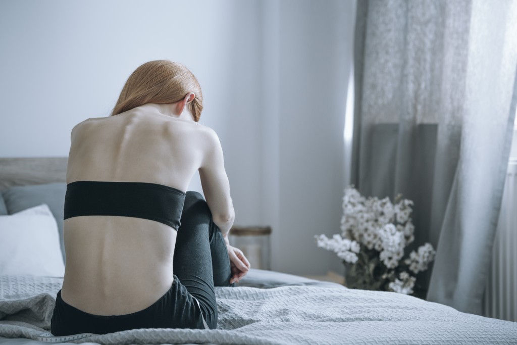 Bulimic woman sitting on a bed