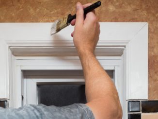 person painting the door frame white