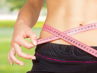 slim woman with tape measure on her waist