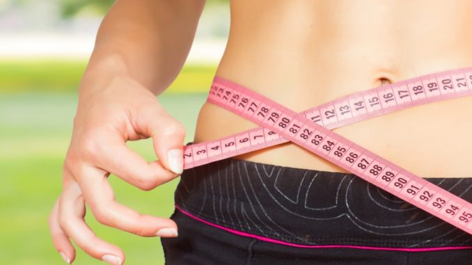 slim woman with tape measure on her waist