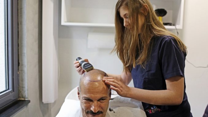 a man getting is head shaved