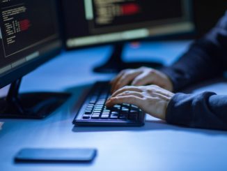 person's hands typing in keyboard