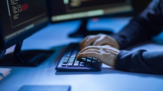 person's hands typing in keyboard