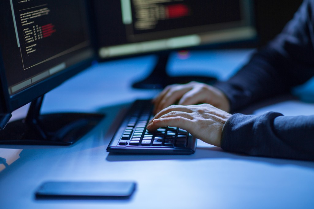 person's hands typing in keyboard