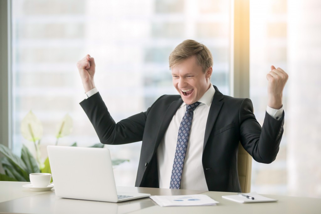 Young happy businessman with really impressive achievements