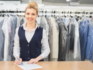 Laundry worker with clothes hanging behind her