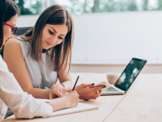 women signing papers