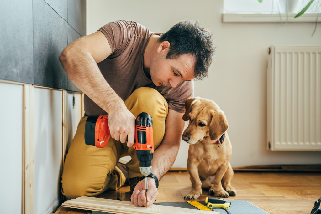 Man doing DIY work with his dog