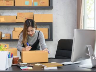 woman writing on package